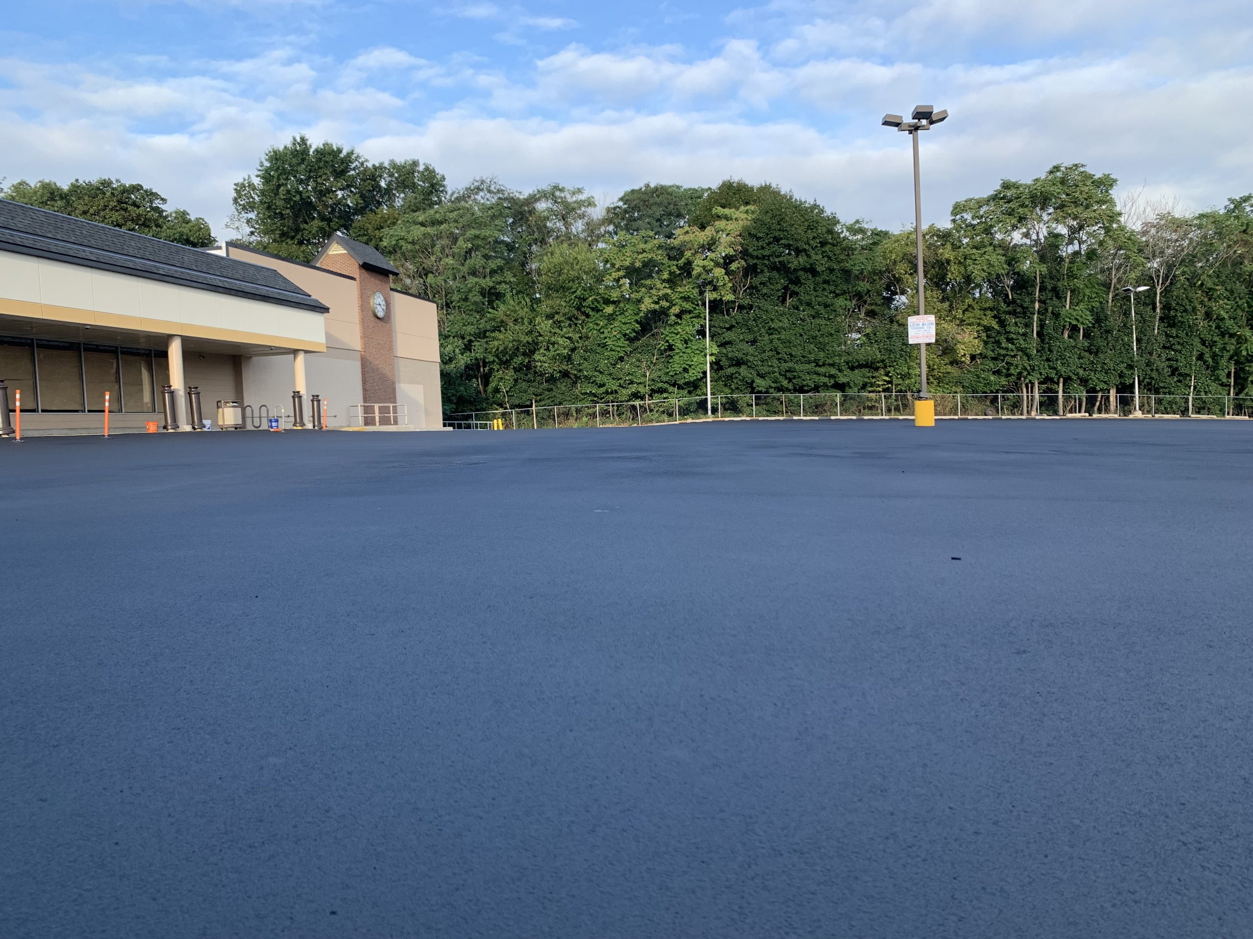 A newly sealed parking lot, not yet striped